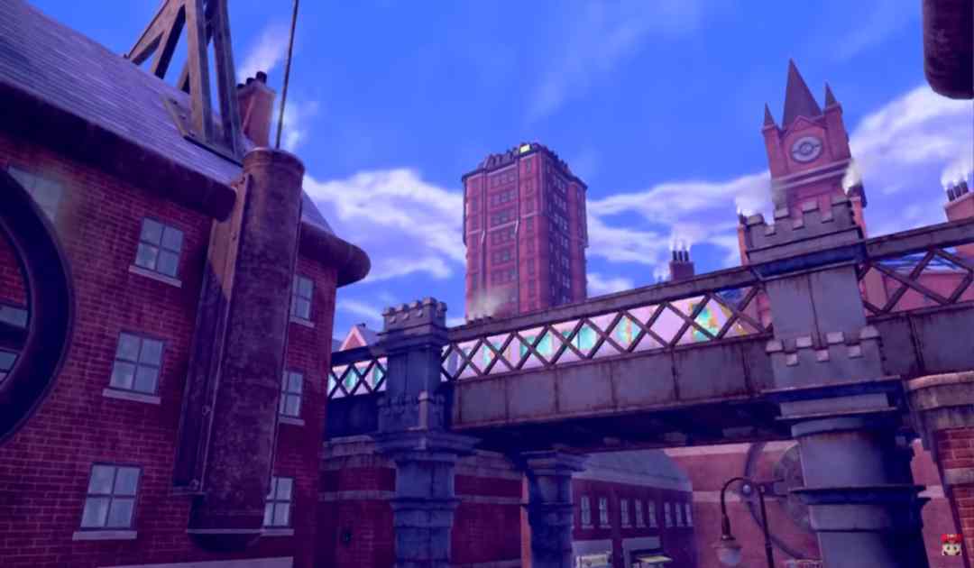 Screenshot dal trailer che mostra un treno sfrecciare all'interno della metropoli dai mattoni rossi