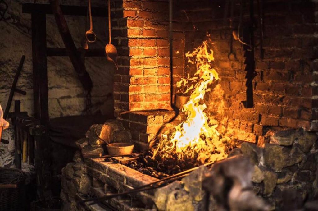 L'antica fucina di un fabbro, con la forgia accesa e pronta al lavoro