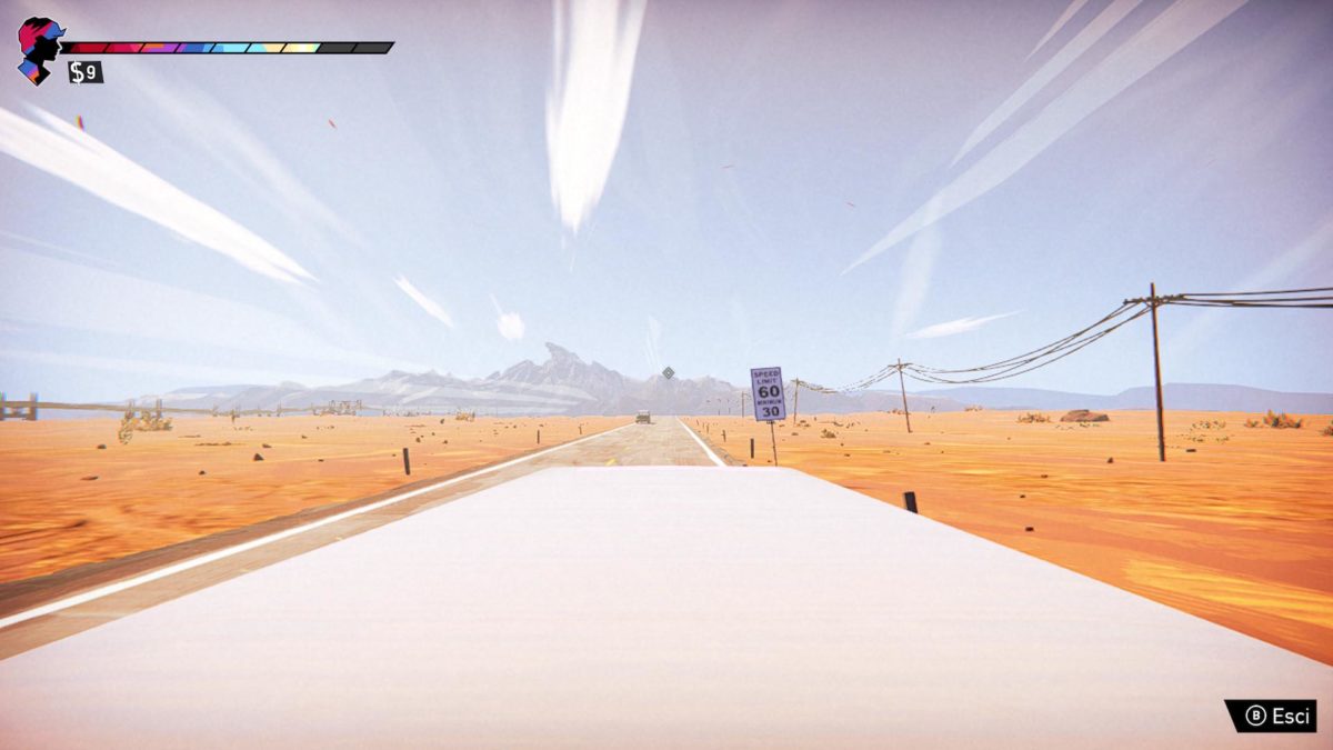 Strada che attraversa un deserto arido con delle montagne sullo sfondo, vista dal tettuccio di una limousine