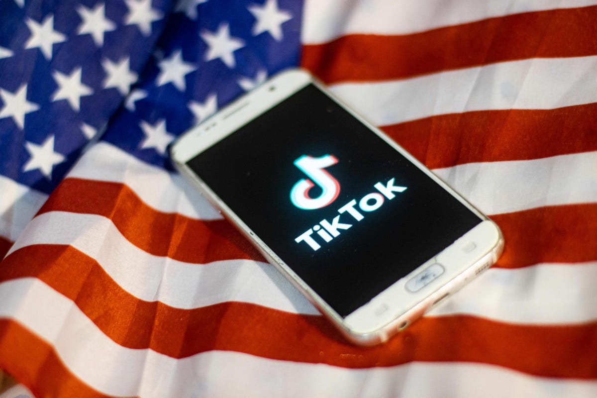 Un cellulare con TikTok posato sopra una bandiera americana.