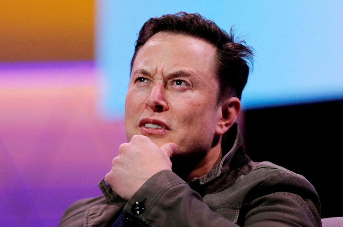 Elon Musk si tocca il mento con uno sguardo pensieroso.