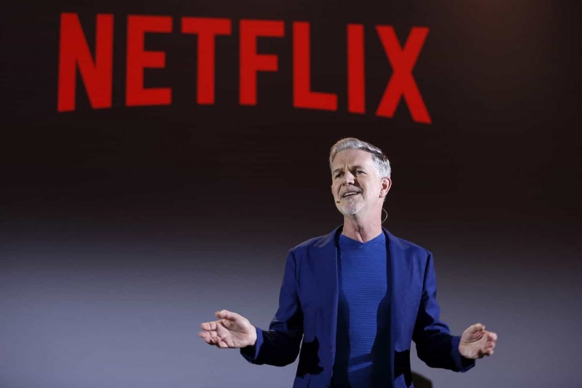 Reed Hastings con alle spalle il logo di Netflix