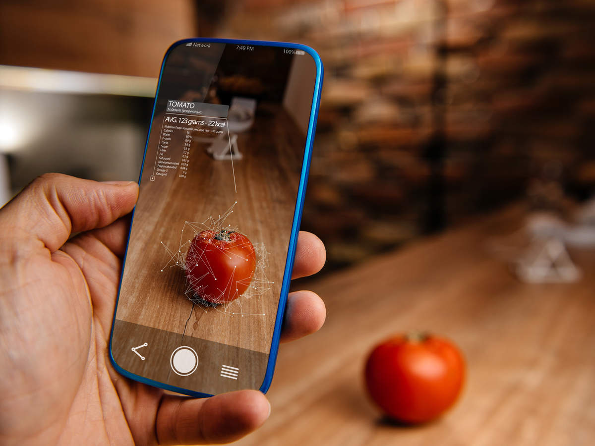 Uno smartphone inquadra un pomodoro valutandone le dimensioni e le calorie