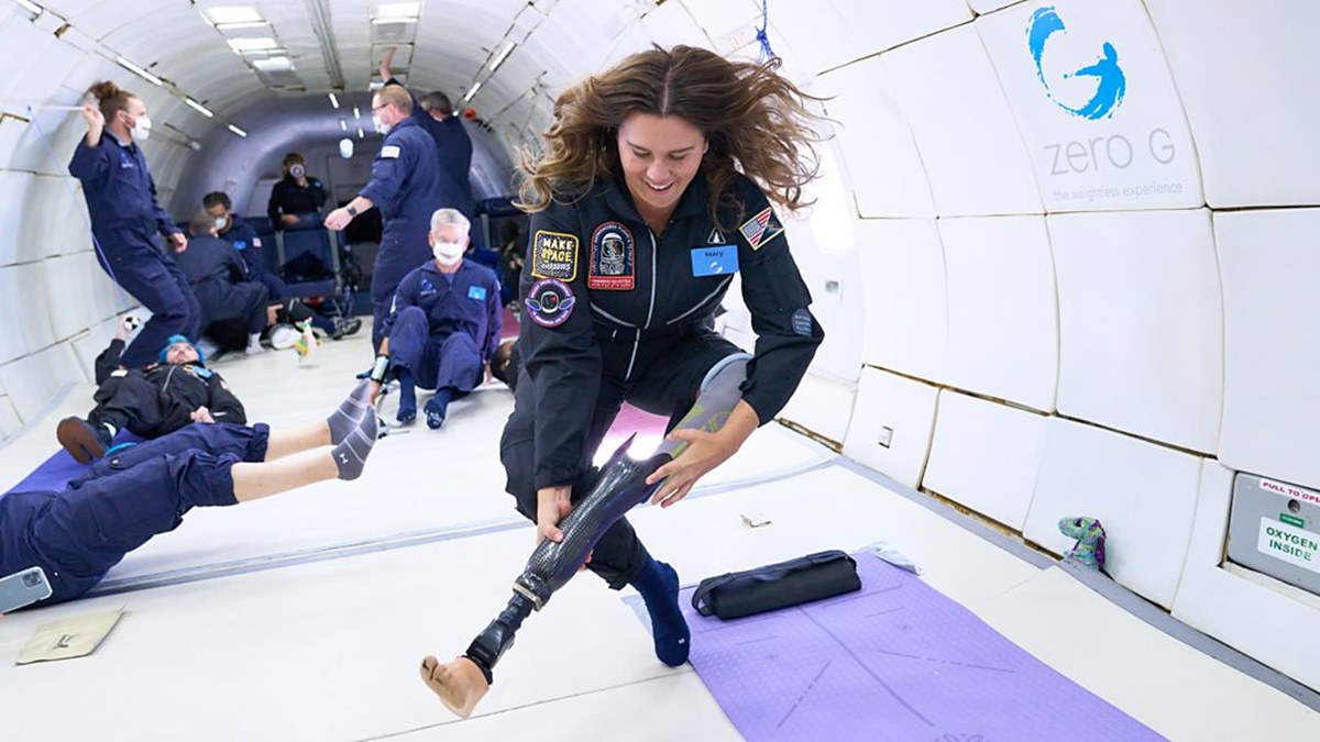 Una donna sfila la protesi dalla gamba mentre lievita in aria durante un lancio a gravità zero