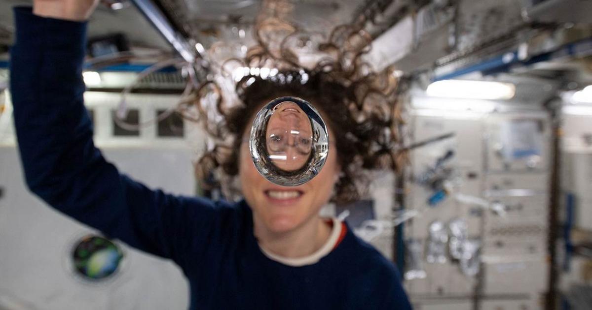 Una goccia d'acqua galleggia di fronte il viso di un'astronauta
