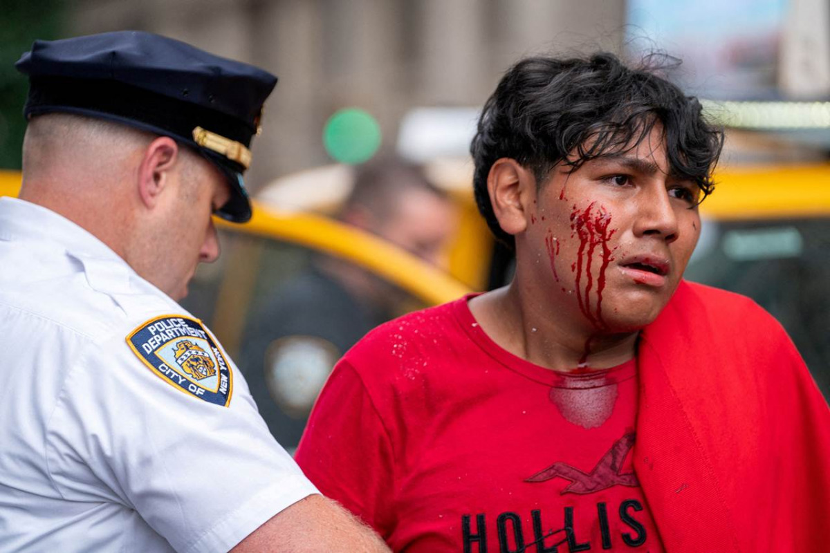 Un agente di polizia arresta un ragazzino ferito durante l'evento di Kai Cenat a New York