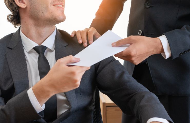 datore che porge busta paga al dipendente