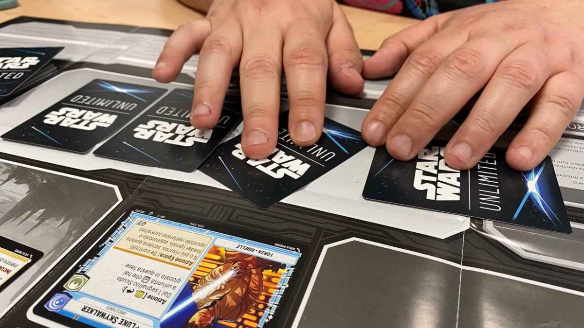Mani di un giocatore che gira carte coperte di Star Wars Unlimited