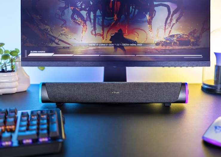 una soundbar da gaming sotto un monitor e con a fianco una tastiera