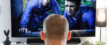 un ragazzo davanti a una tv con un videogioco e una soundbar