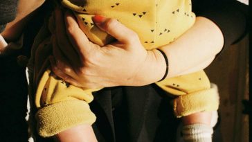 Mamma con un figlio in braccio