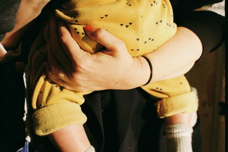 Mamma con un figlio in braccio