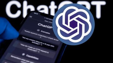 Il logo di OpenAI e una mano che regge un telefono con ChatGPT