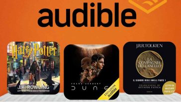 sfondo arancione con logo Audible e le copertine degli audiolibri di Harry Potter, Dune e Signore degli Anelli appoggiate su uno scaffale bianco