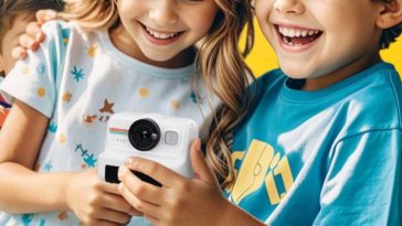 due bambini che tengono una macchina fotografica istantanea tra le mani