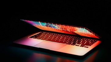 Un laptop socchiuso su sfondo scuro