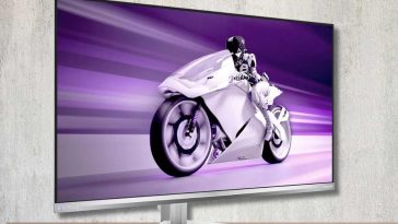 Monitor Philips Evnia appoggiato su una mensola di legno con dietro un muro bianco