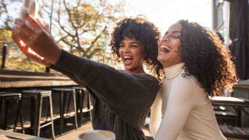 ragazze sedute a un tavolino che fanno una foto