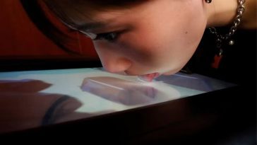 Donna lecca schermo per sentire i sapori della TV