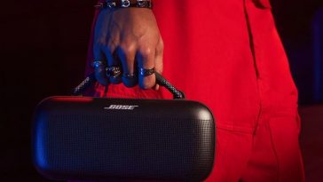 uomo con pantaloni rossi e bracciali trasporta la cassa portatile Bose dal manico