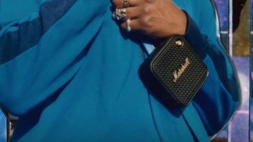 mano di ragazzo con felpa azzurra tiene in mano cassa Marshall