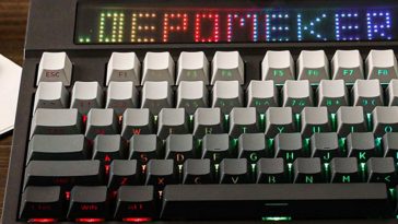 Tastiera epomaker ripresa per metà su scrivania, con schermo con su scritto "EPOMAKER" con lettere di vari colori