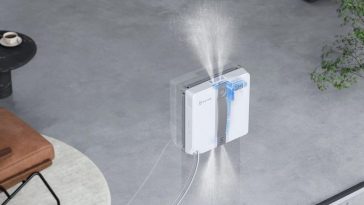 Robot lavavetri che si muove su vetro mentre atomizza acqua