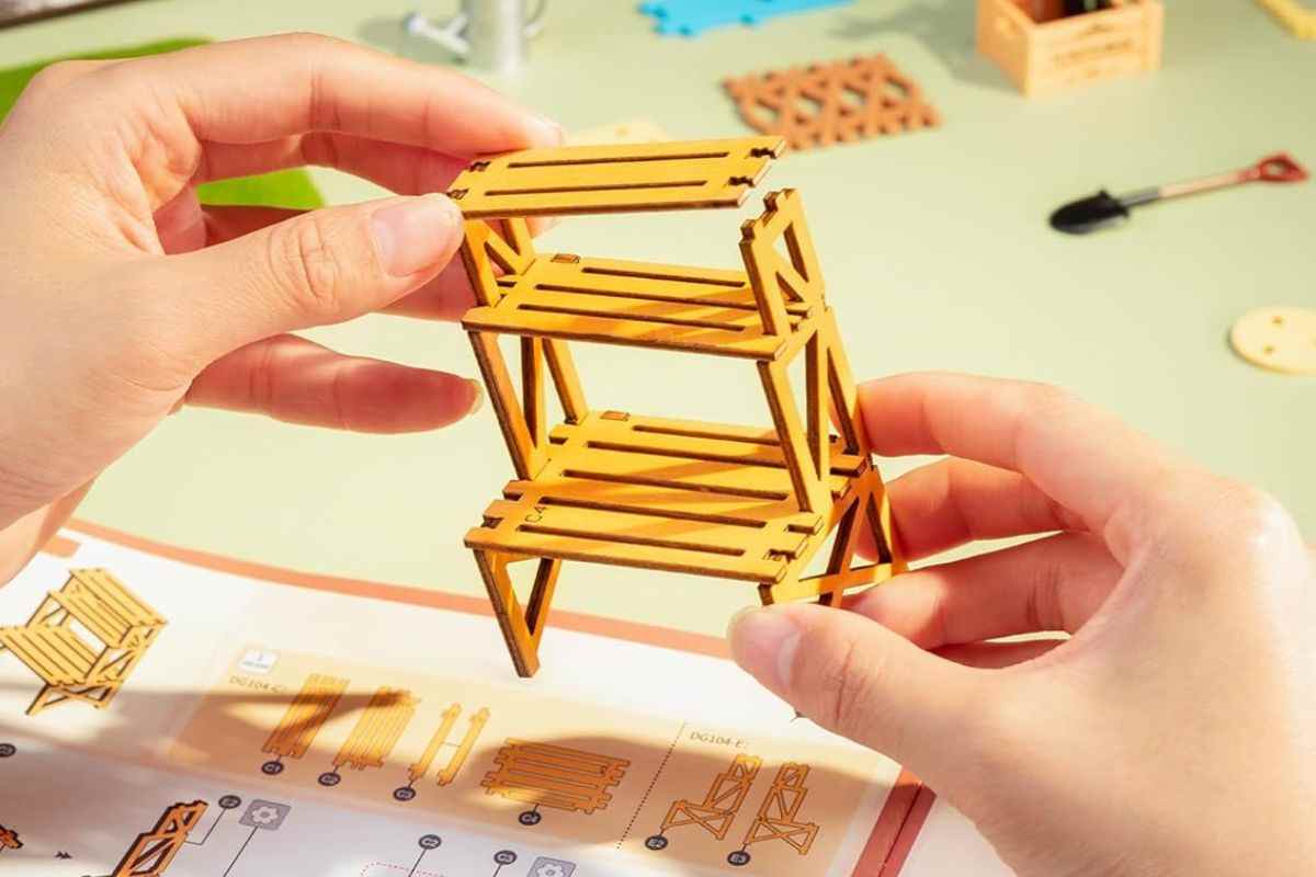 due mani montano un modellino di mensola espositore