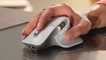 Mouse Logitech tenuto in mano su superficie riflettente