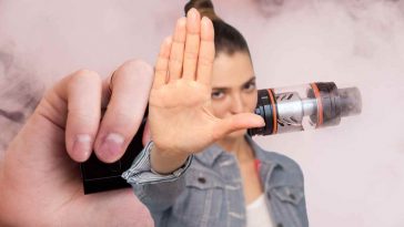 donna con la mano avanti e dietro una sigaretta elettronica