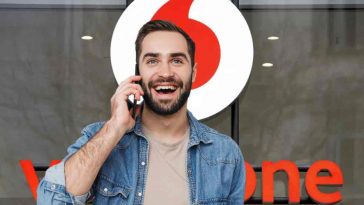 uomo con smartphone vodafone sullo sfondo