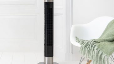 ventilatore a torre princess di fianco a una sedia bianca e davanti a una porta