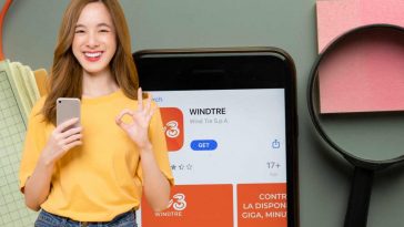 smartphone con app windtre e ragazza con il cellulare in mano che sorride