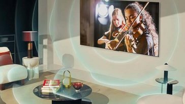 TV OLED Evo LG serie gs4 sulla parete con ragazza che suona il violino sullo schermo e onde sonore