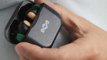 persona che tiene in mano gli auricolari in legno Marley house of the little bird all'interno della custodia