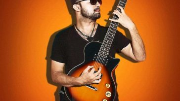 Persona che suona chitarra Donner LP su sfondo arancione