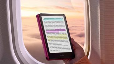 persona legge Kinlde in aereo, alle spalle finestrino aereo in volo