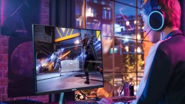 ragazzo seduto davanti a monitor da gaming alla scrivania