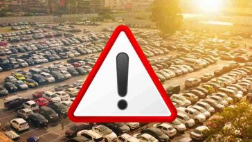 parcheggio pieno di auto con triangolo di pericolo