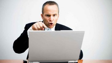 uomo che grida verso lo schermo del pc