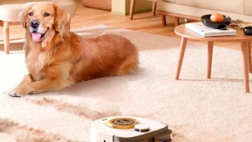 Robot aspirapolvere UBPET su tappeto accanto a cane sdraiato vicino a tavolinetto e divano