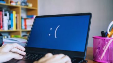 faccina triste su sfondo blu di un computer portatile