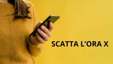 donna vestita di giallo con telefono in mano