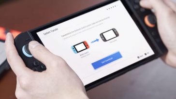 persona che tiene in mano una Switch 2 mentre trasferisce file