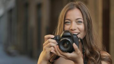 Ragazza con una macchina fotografica pronta a scattare una foto