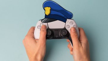 persona che tiene in mano un dualsense ps5 con un cappello della polizia sopra