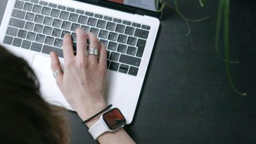 Una mano che scrive su una tastiera di un portatile