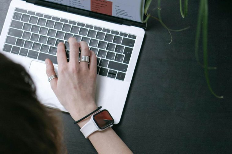 Una mano che scrive su una tastiera di un portatile