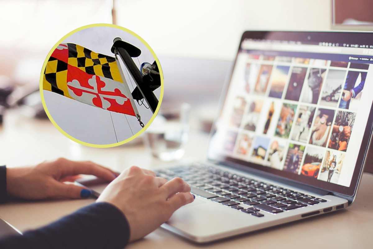 Mani sulla tastiera di un portatile e, in evidenza, la bandiera del Maryland