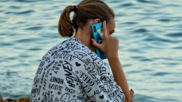Una ragazza che parla al telefono al mare